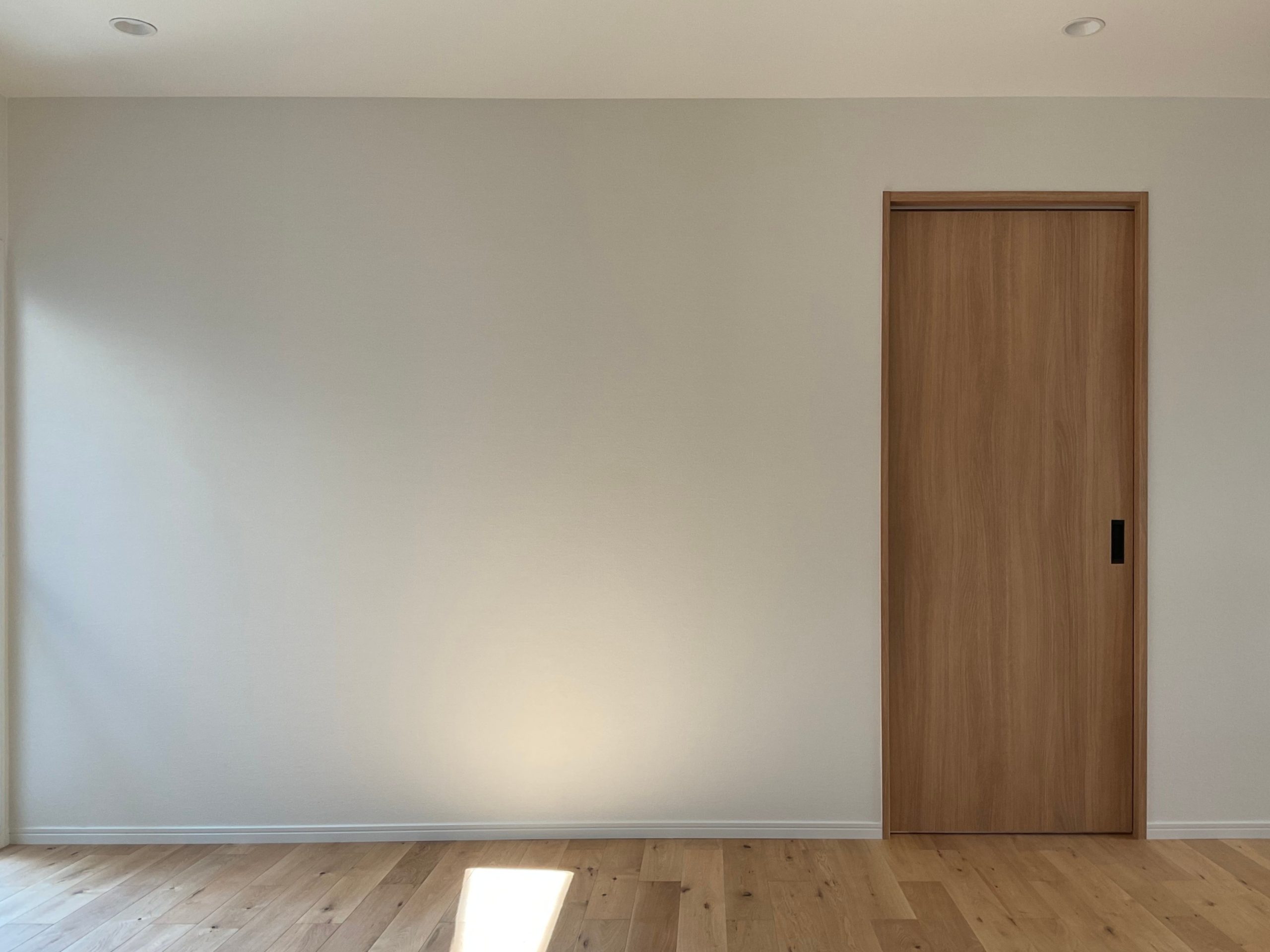 神戸市西区で施工したL洋室リフォーム事例。床にはオークの無垢フローリング、壁はウォームホワイトのクロスを採用し、木のぬくもりとやさしい色味が調和した、あたたかみのある空間に